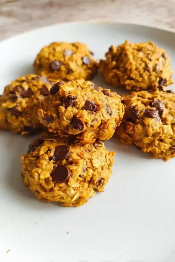 Freshly baked pumpkin oatmeal chocolate chip cookies cooling on wire rack after baking