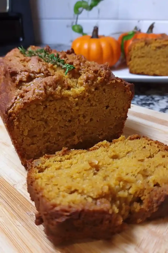 Hands folding butternut squash puree into bread batter in mixing bowl during butternut squash bread recipe preparation
