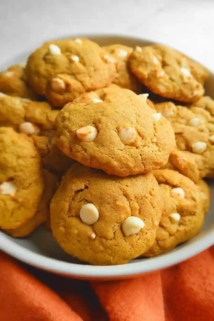 Freshly baked pumpkin white chocolate chip cookies cooling on wire rack after baking