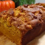 Freshly baked butternut squash bread sliced on wooden cutting board showing moist texture and golden color