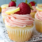 Delicious strawberry lemonade cupcakes topped with pink strawberry buttercream frosting and fresh strawberry garnish