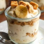Cottage cheese banana pudding served in glass bowl with whipped cream and banana slices on marble counter