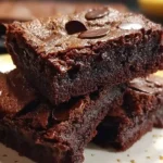 Fudgy cottage cheese brownies cut into squares on white plate with fork, showing dense chocolate texture