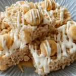 Banana Pudding Rice Krispie Treats topped with vanilla wafers and white chocolate drizzle