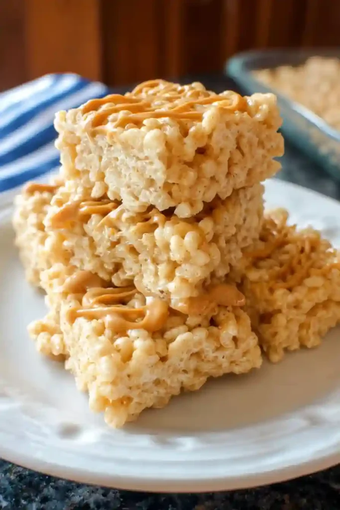 Knife cutting set peanut butter rice krispie treats into uniform squares in baking pan